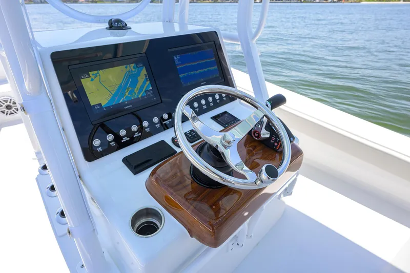  Yacht Photos Pics 2024 Conch 25 boat dashboard with navigation screens and steering wheel on open water.