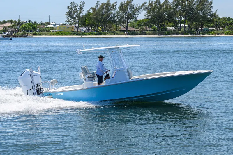  Yacht Photos Pics 2024 Conch 25 boat cruising on a sunny day in calm waters.