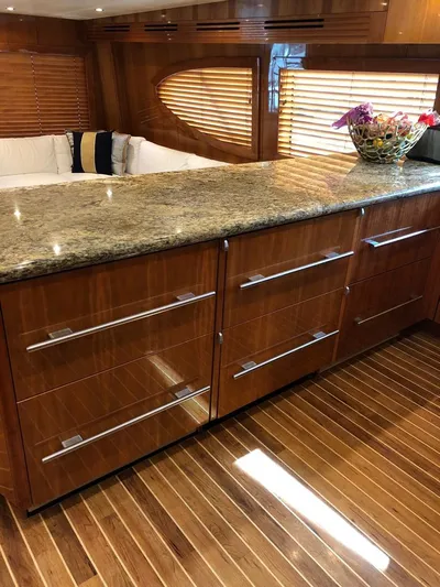  Yacht Photos Pics Luxurious interior of 2007 Hatteras 68 Convertible yacht with granite countertop and wooden cabinetry.