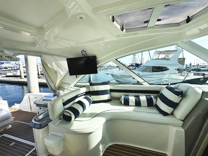Rogue Yacht Photos Pics Luxurious interior of 2006 Sea Ray 48 Sundancer yacht with striped cushions and marina view.