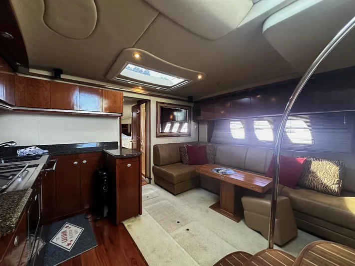Rogue Yacht Photos Pics Luxurious interior of 2006 Sea Ray 48 Sundancer yacht with modern kitchen and cozy seating area.