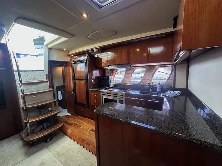 Rogue Yacht Photos Pics Interior of 2006 Sea Ray 48 Sundancer yacht with modern kitchen and wooden cabinetry.