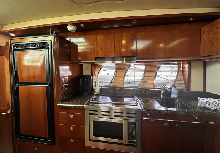Rogue Yacht Photos Pics Luxurious kitchen interior of 2006 Sea Ray 48 Sundancer yacht with wood cabinetry.