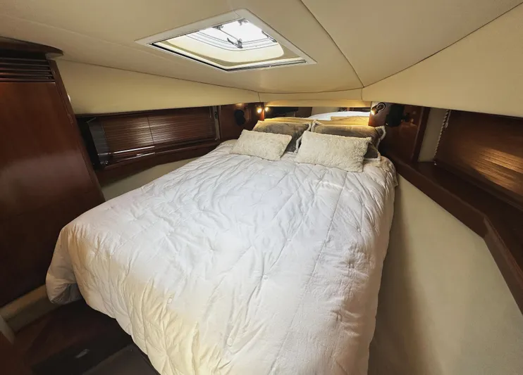 Rogue Yacht Photos Pics Luxurious bedroom interior of 2006 Sea Ray 48 Sundancer yacht with skylight and cozy bedding.