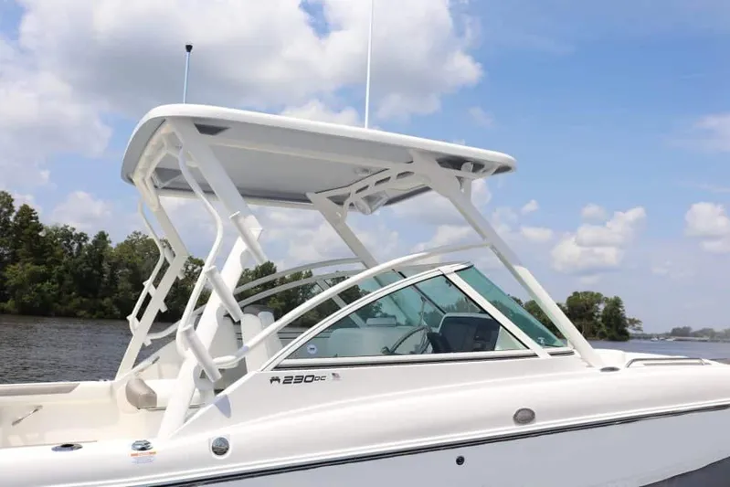 51980 230dc Nap Yacht Photos Pics Manufacturer Provided Image: 2025 World Cat 230 DC boat with sleek design on a calm river under blue skies.