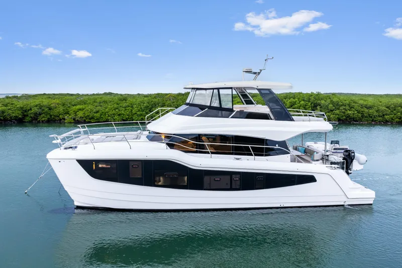  Yacht Photos Pics 2026 Aquila 50 Yacht cruising on calm waters under a clear blue sky.