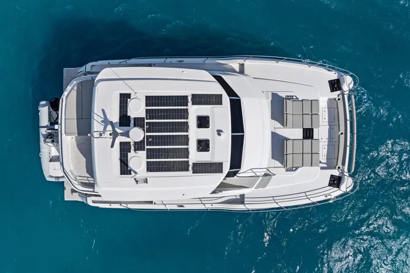  Yacht Photos Pics Aerial view of 2026 Aquila 50 Yacht with solar panels on turquoise water.