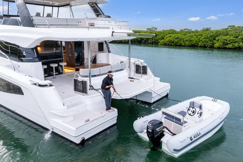  Yacht Photos Pics Aquila 50 Yacht 2026 with tender boat on calm water, featuring modern design.