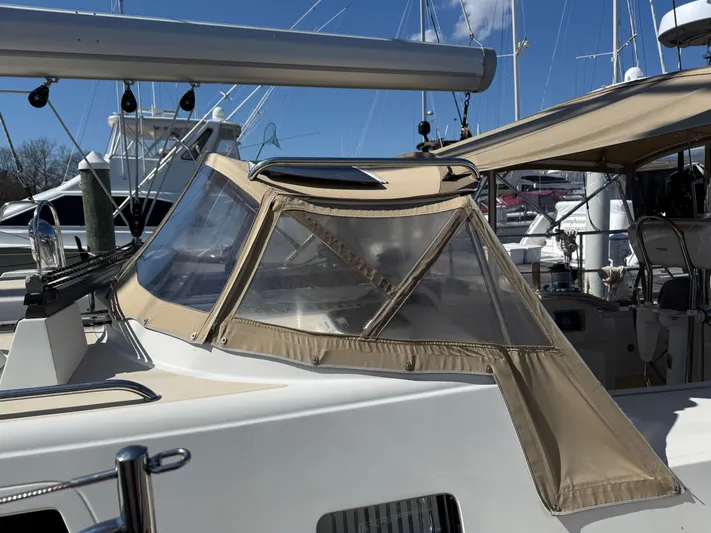 Aevitas Yacht Photos Pics Sailboat cockpit with beige canopy, Outbound 46, 2011 model, docked at marina.