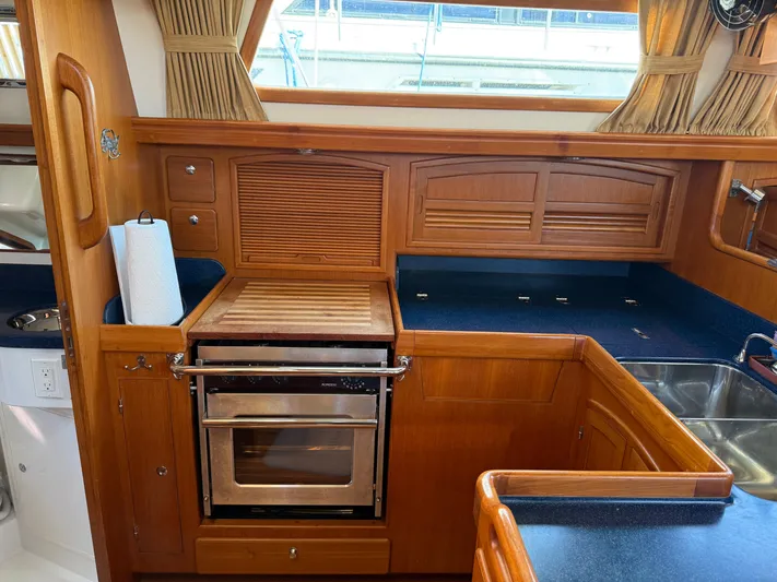 Aevitas Yacht Photos Pics Luxurious 2011 Outbound 46 yacht kitchen with wood cabinetry and modern appliances.