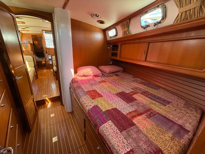Aevitas Yacht Photos Pics Cozy cabin interior of 2011 Outbound 46 yacht with wooden finish and colorful bedspread.
