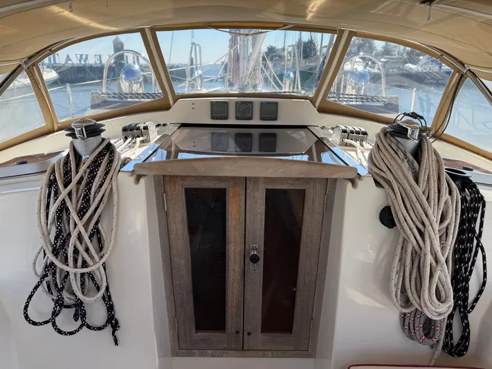 Aevitas Yacht Photos Pics Cockpit of 2011 Outbound 46 sailboat with ropes and wooden cabinet.