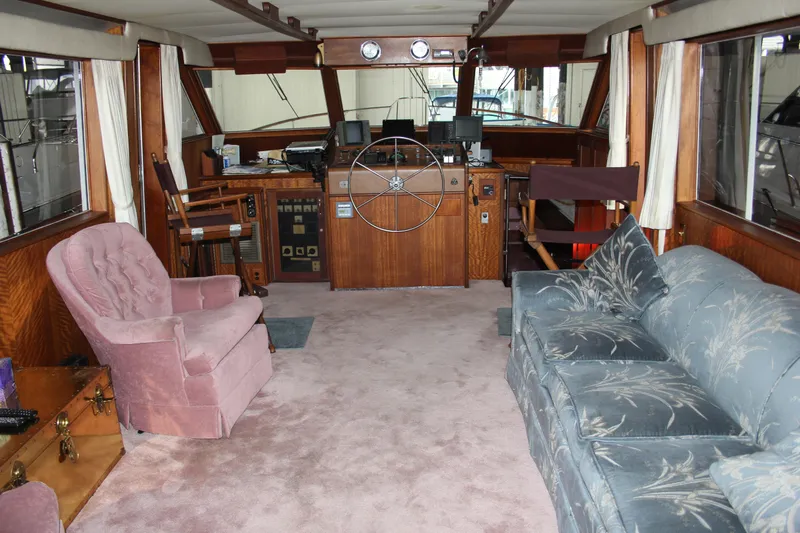 Apple 1 Yacht Photos Pics Interior of 1974 Hatteras 58 Yachtfish with plush seating and classic wooden helm.