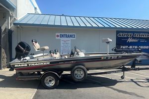 2001 Bass Tracker Pro Team 175 boat on trailer outside a fishing store.