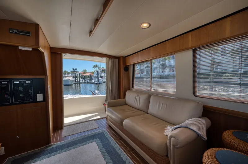 Oasis Yacht Photos Pics Interior of 2006 Mainship 34 Trawler with sofa and harbor view.