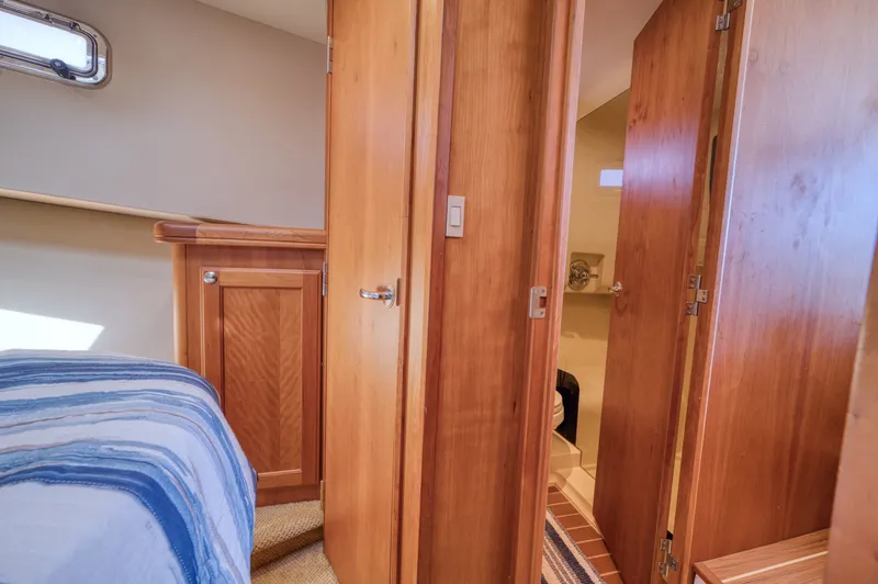 Oasis Yacht Photos Pics Interior of a 2006 Mainship 34 Trawler with wooden doors and bed.