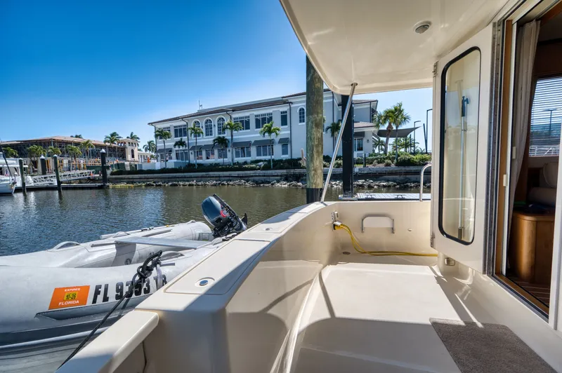 Oasis Yacht Photos Pics 2006 Mainship 34 Trawler docked with dinghy and waterfront view.