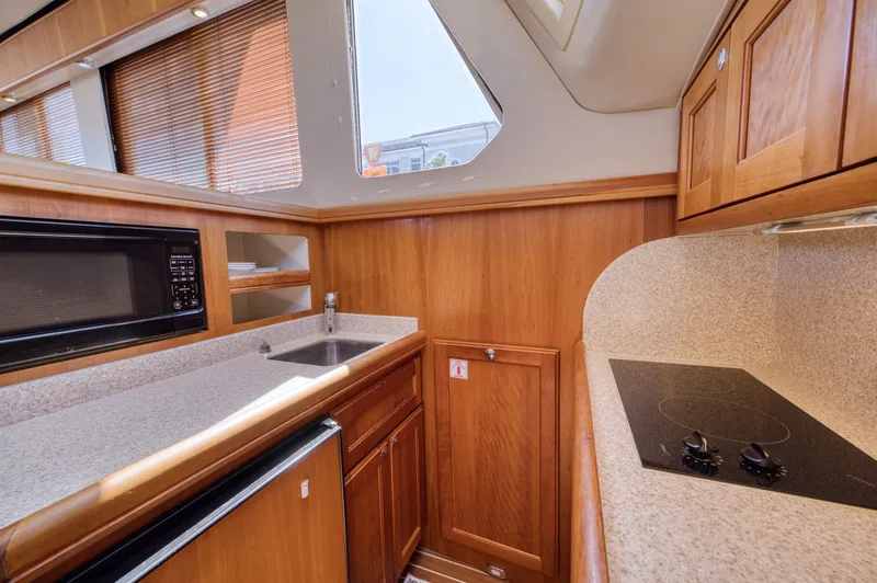 Oasis Yacht Photos Pics Interior of 2006 Mainship 34 Trawler with kitchen and wood paneling.