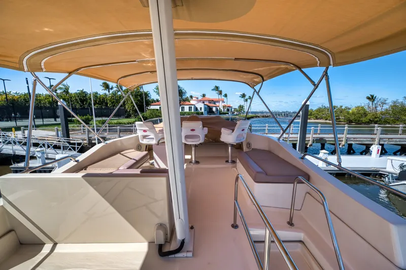 Oasis Yacht Photos Pics 2006 Mainship 34 Trawler with covered deck and seating area by the water.