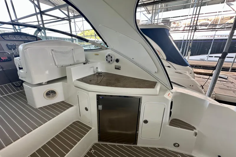 Somewhere With You Yacht Photos Pics 2009 Cruisers Yachts 460 Express interior with sink and seating area in a marina setting.