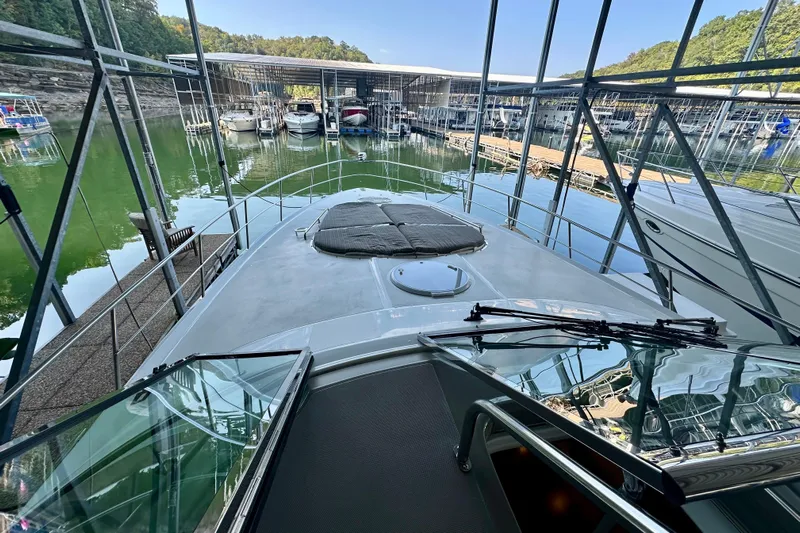 Somewhere With You Yacht Photos Pics 2009 Cruisers Yachts 460 Express docked in a marina, surrounded by boats.