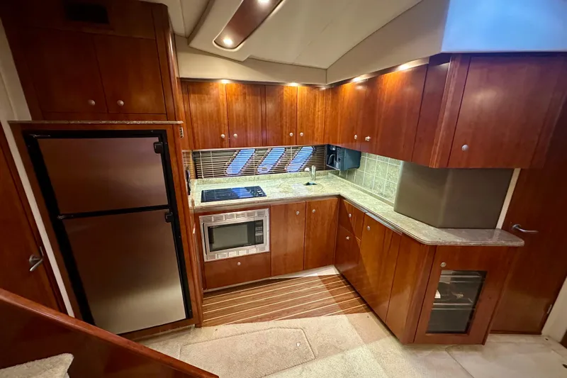 Somewhere With You Yacht Photos Pics Luxurious 2009 Cruisers Yachts 460 Express kitchen with wood cabinetry and modern appliances.