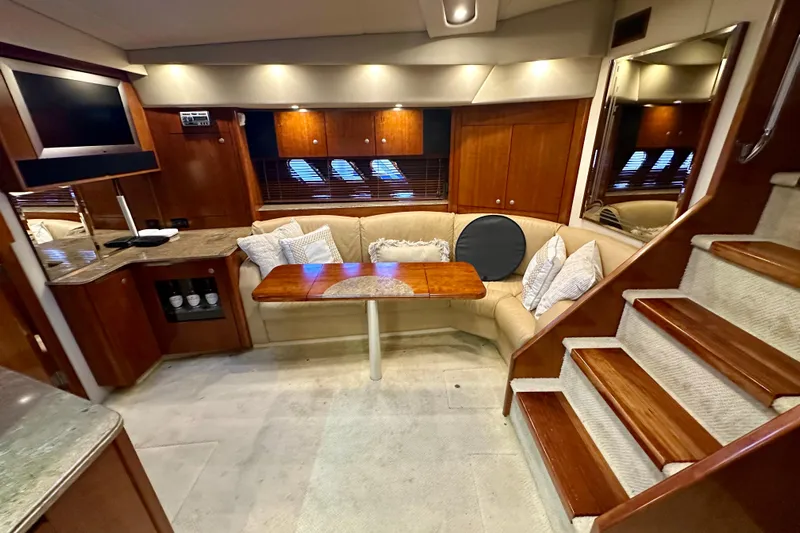 Somewhere With You Yacht Photos Pics Luxurious interior of 2009 Cruisers Yachts 460 Express with cozy seating and elegant wood finishes.