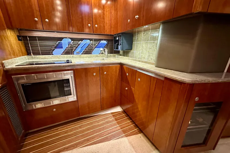 Somewhere With You Yacht Photos Pics Luxurious 2009 Cruisers Yachts 460 Express kitchen with wood cabinetry and modern appliances.