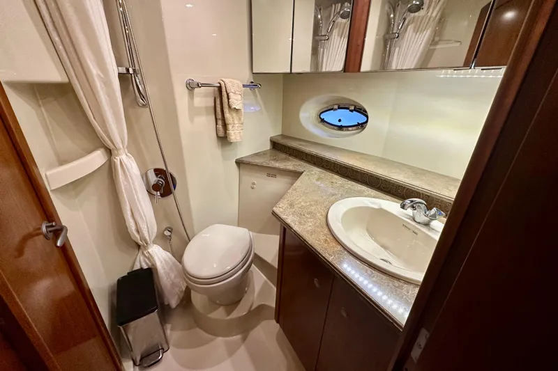 Somewhere With You Yacht Photos Pics Luxurious bathroom in 2009 Cruisers Yachts 460 Express with elegant fixtures and porthole window.
