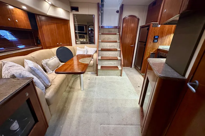 Somewhere With You Yacht Photos Pics Luxurious interior of 2009 Cruisers Yachts 460 Express with elegant wood finishes and cozy seating.
