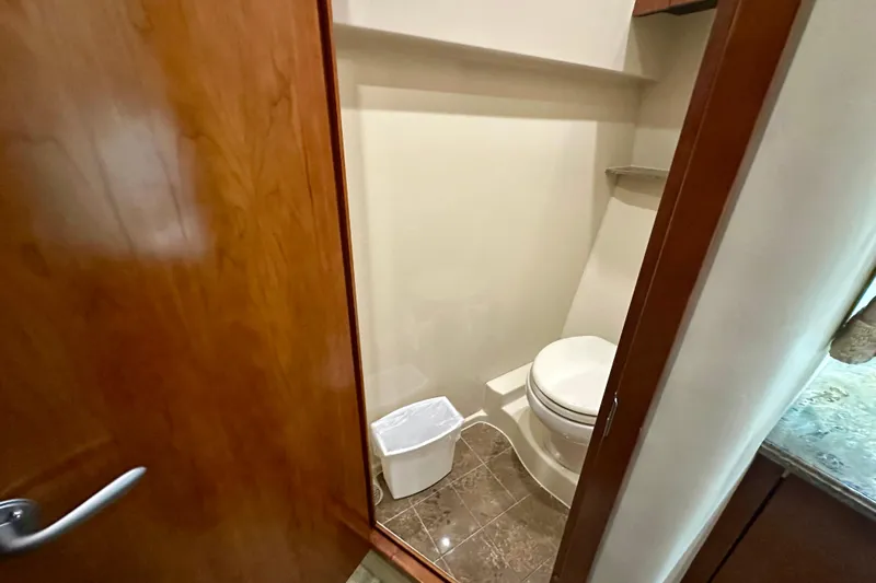 Somewhere With You Yacht Photos Pics 2009 Cruisers Yachts 460 Express bathroom with wooden door and modern fixtures.