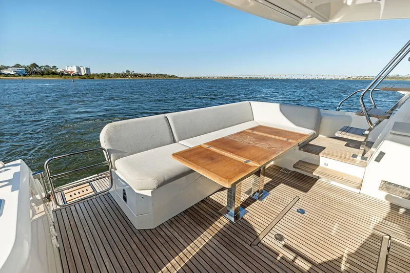 Pure De Papas Yacht Photos Pics Prestige 520 Fly 2019 yacht deck with seating and table, overlooking serene water.