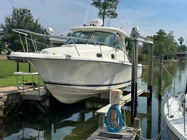  Yacht Photos Pics 2012 Pursuit OS 315 Offshore boat docked on a lift by a canal.
