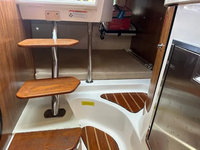  Yacht Photos Pics 2012 Pursuit OS 315 Offshore cabin interior with wooden steps and compact design.
