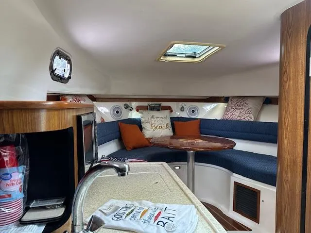  Yacht Photos Pics 2012 Pursuit OS 315 Offshore cabin with cozy seating, table, and kitchenette.