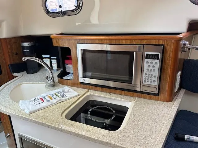  Yacht Photos Pics 2012 Pursuit OS 315 Offshore galley with microwave, sink, and countertop.