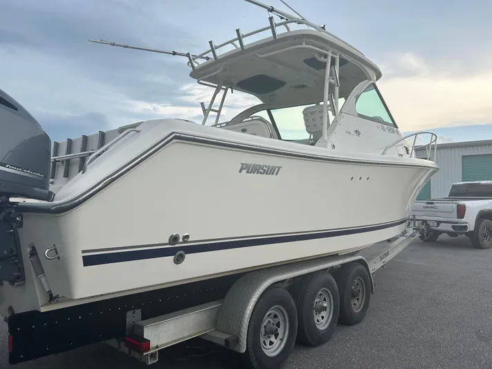  Yacht Photos Pics 2012 Pursuit OS 315 Offshore boat on trailer, parked near a GMC truck.