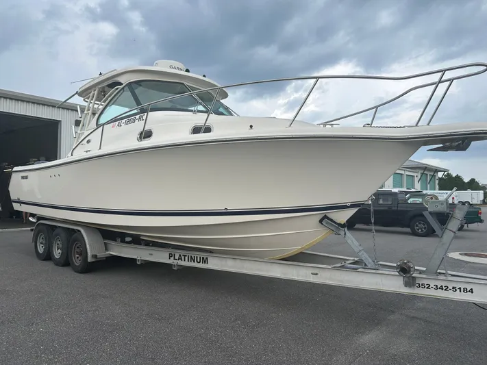  Yacht Photos Pics 2012 Pursuit OS 315 Offshore boat on trailer, parked outdoors under cloudy sky.
