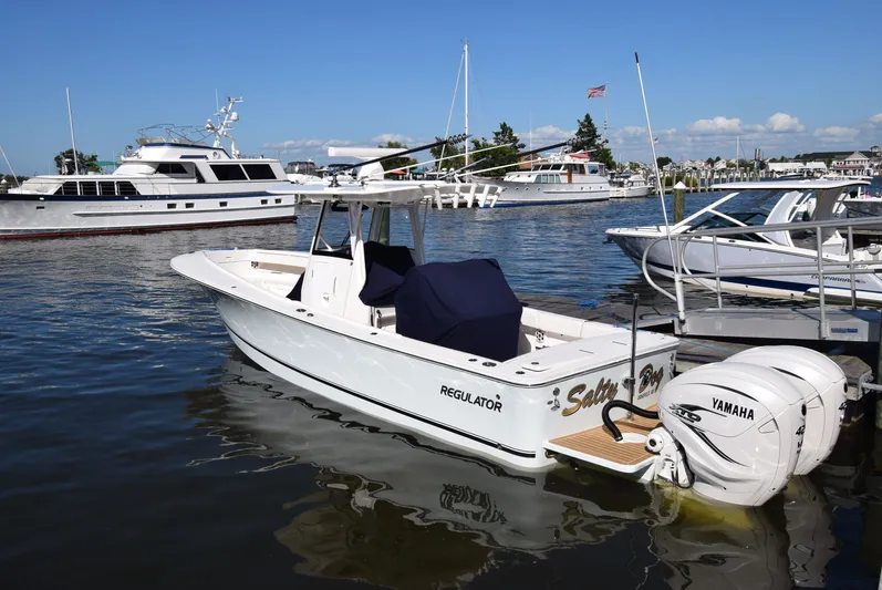 Salty Dog Yacht Photos Pics 2023 Regulator 31 boat docked with Yamaha engine, surrounded by other boats.