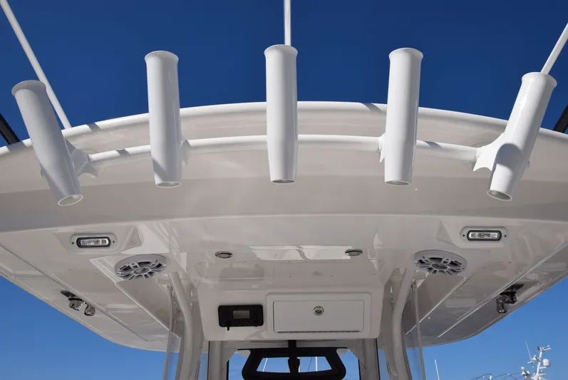 Salty Dog Yacht Photos Pics 2023 Regulator 31 boat with rod holders and speakers under a clear blue sky.