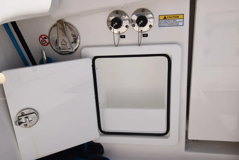 Salty Dog Yacht Photos Pics 2023 Regulator 31 boat storage compartment with open hatch and caution label.