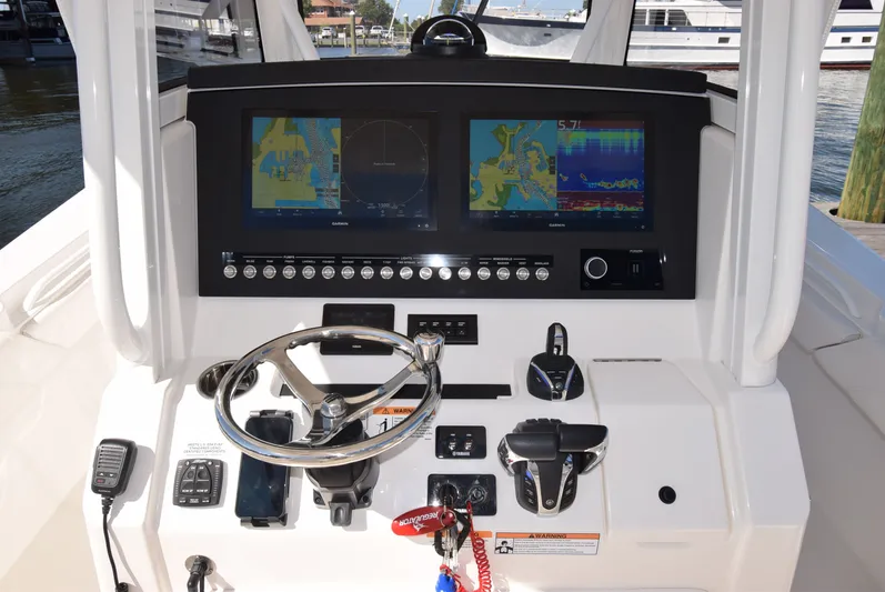 Salty Dog Yacht Photos Pics Control panel of 2023 Regulator 31 boat with navigation screens and steering wheel.