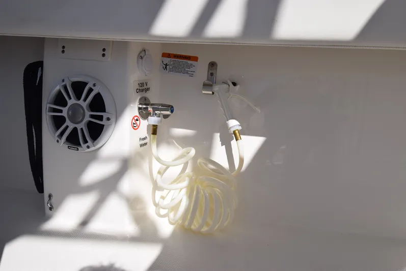 Salty Dog Yacht Photos Pics 2023 Regulator 31 boat interior with speaker, 120V charger, and fresh water hose.