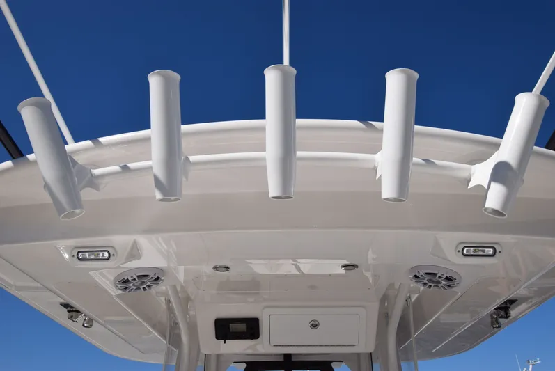 Salty Dog Yacht Photos Pics 2023 Regulator 31 boat with rod holders and speakers under a clear blue sky.