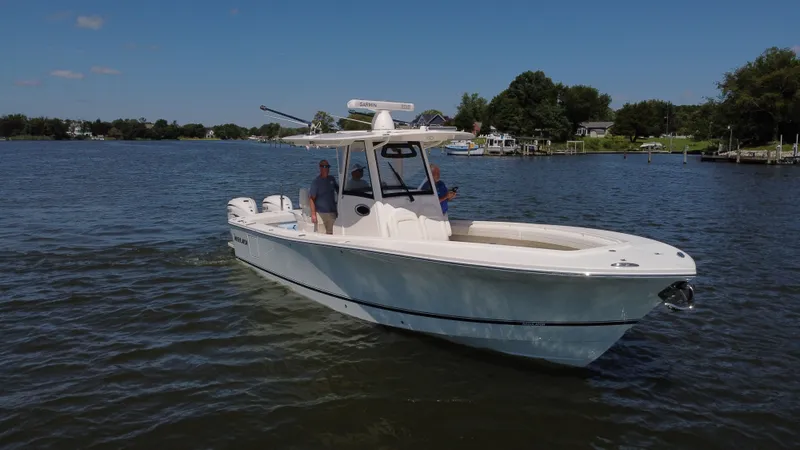 Salty Dog Yacht Photos Pics 2023 Regulator 31 boat cruising on a calm lake under a clear blue sky.