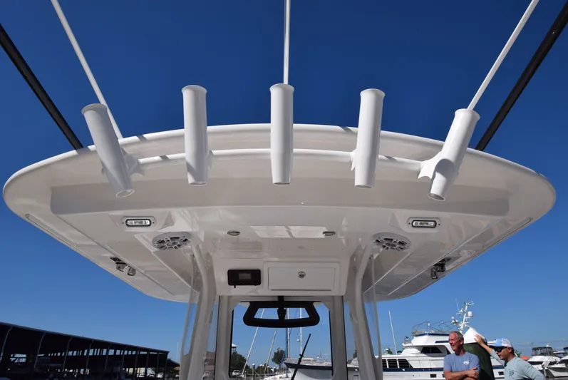 Salty Dog Yacht Photos Pics 2023 Regulator 31 boat with rod holders and speakers under a clear blue sky.