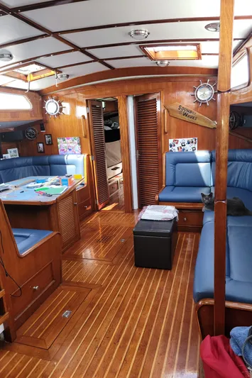 Magic Carpet Yacht Photos Pics Interior of 1983 Challenger Custom 60 yacht with wooden flooring and blue seating.
