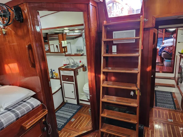 Magic Carpet Yacht Photos Pics Interior of 1983 Challenger Custom 60 yacht with wooden finishes and compact bathroom.