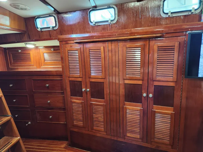 Magic Carpet Yacht Photos Pics 1983 Challenger Custom 60 yacht interior with wooden cabinets and drawers.