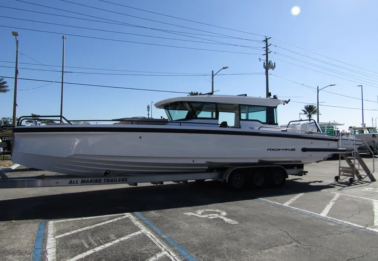  Yacht Photos Pics 2025 Axopar 37XC CROSS CABIN boat on trailer in parking lot.